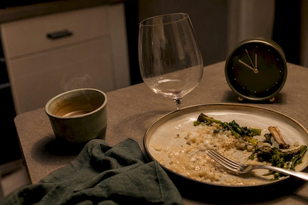 Coffee cup, wine glass, late dinner plate on table