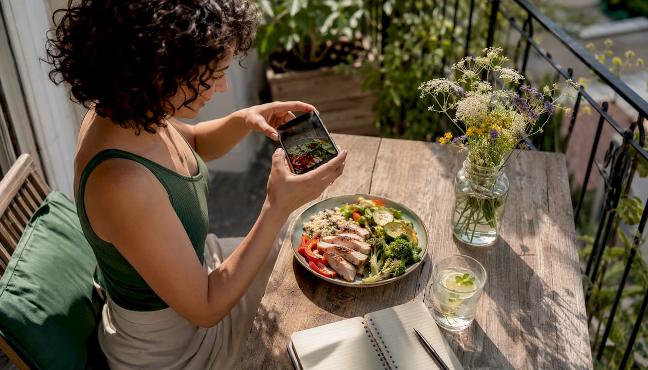 Woman photographing balanced meal for food diary