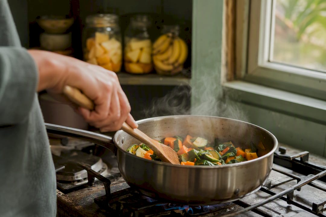 Steaming cooked vegetables in saucepan with hand stirring